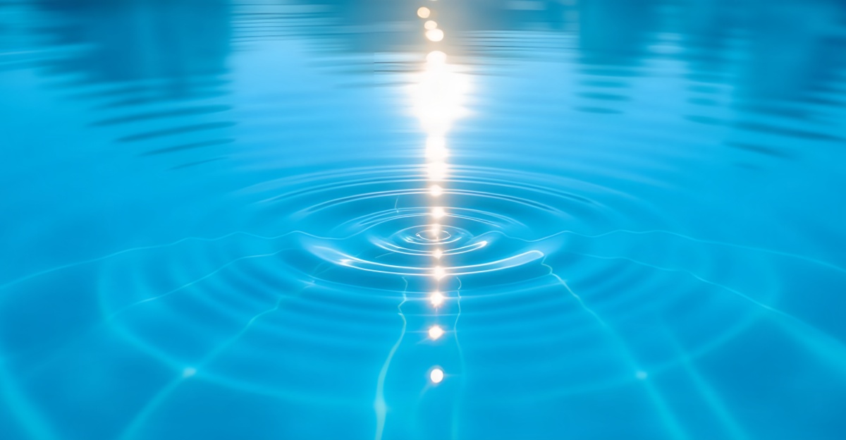 A bright full-width 1200x624 landscape photograph of expanding light ripples on crystalline water, representing the vibration of gratitude multiplying good.