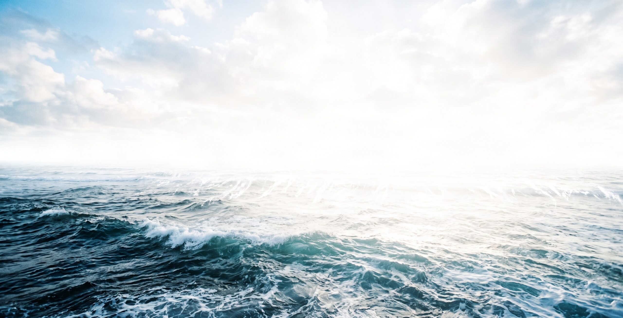A bright full-width 1200x624 landscape photograph of an ocean dissolving into brilliant white sunlight, representing the infinite field of spiritual substance.
